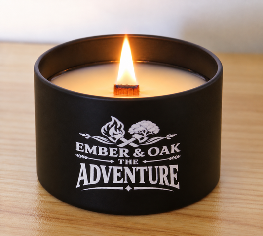 The Adventure 8oz luxury scented candle burning with wooden wick and Ember & Oak branding