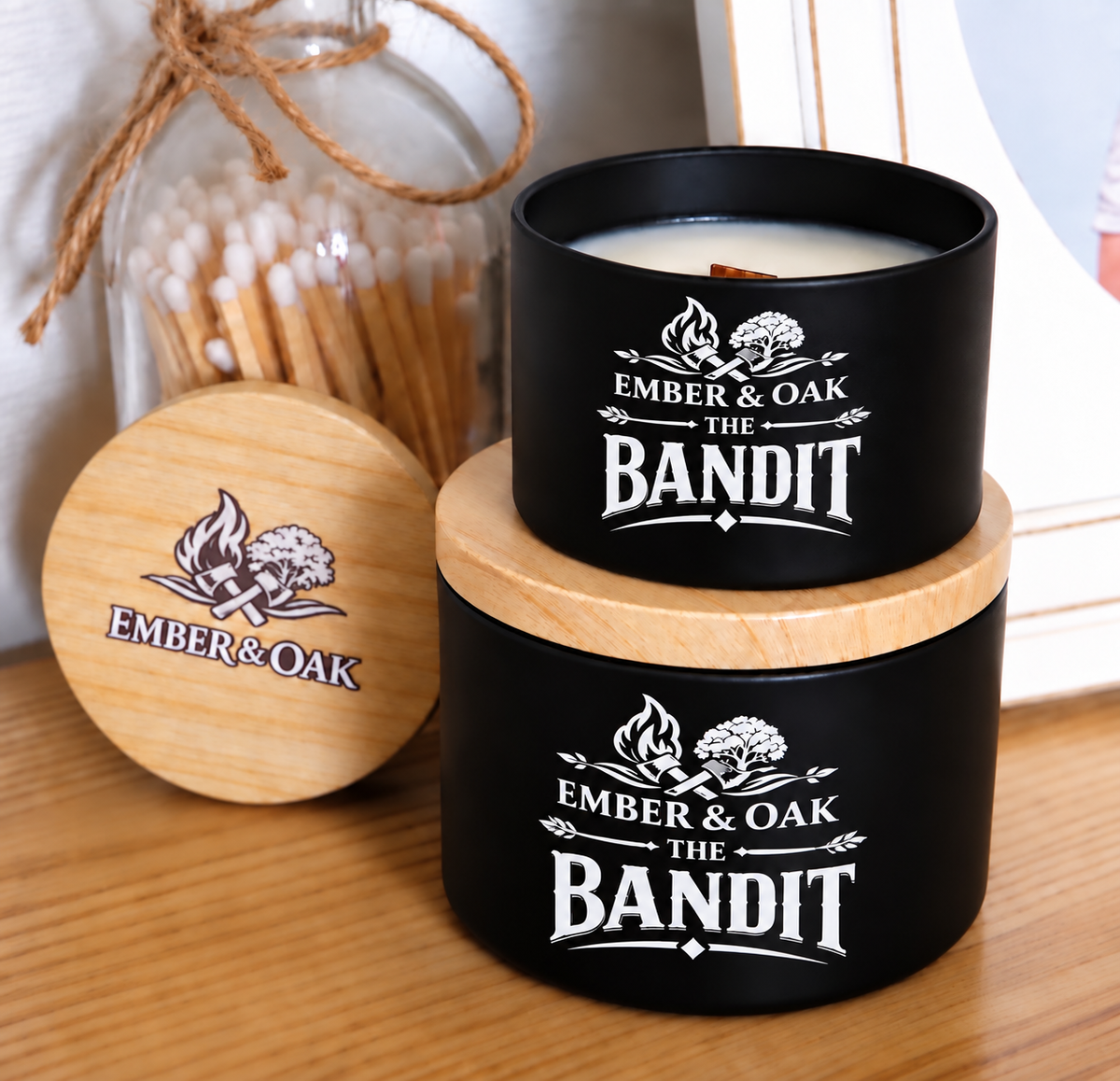     The Bandit luxury candle with wooden lid displayed alongside Ember & Oak packaging and accessories