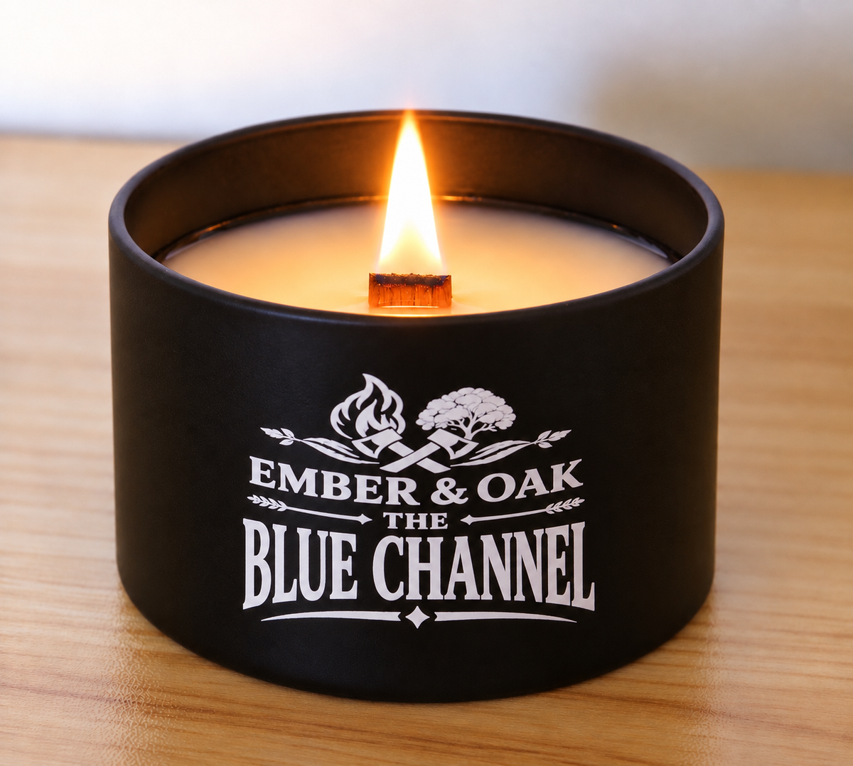     The Blue Channel 8oz luxury scented candle burning with wooden wick and Ember & Oak branding