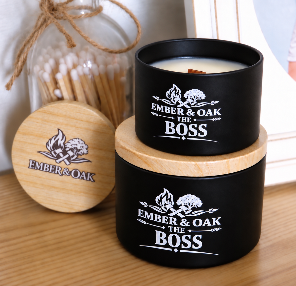     The Boss luxury candle with wooden lid displayed alongside Ember & Oak packaging and accessories