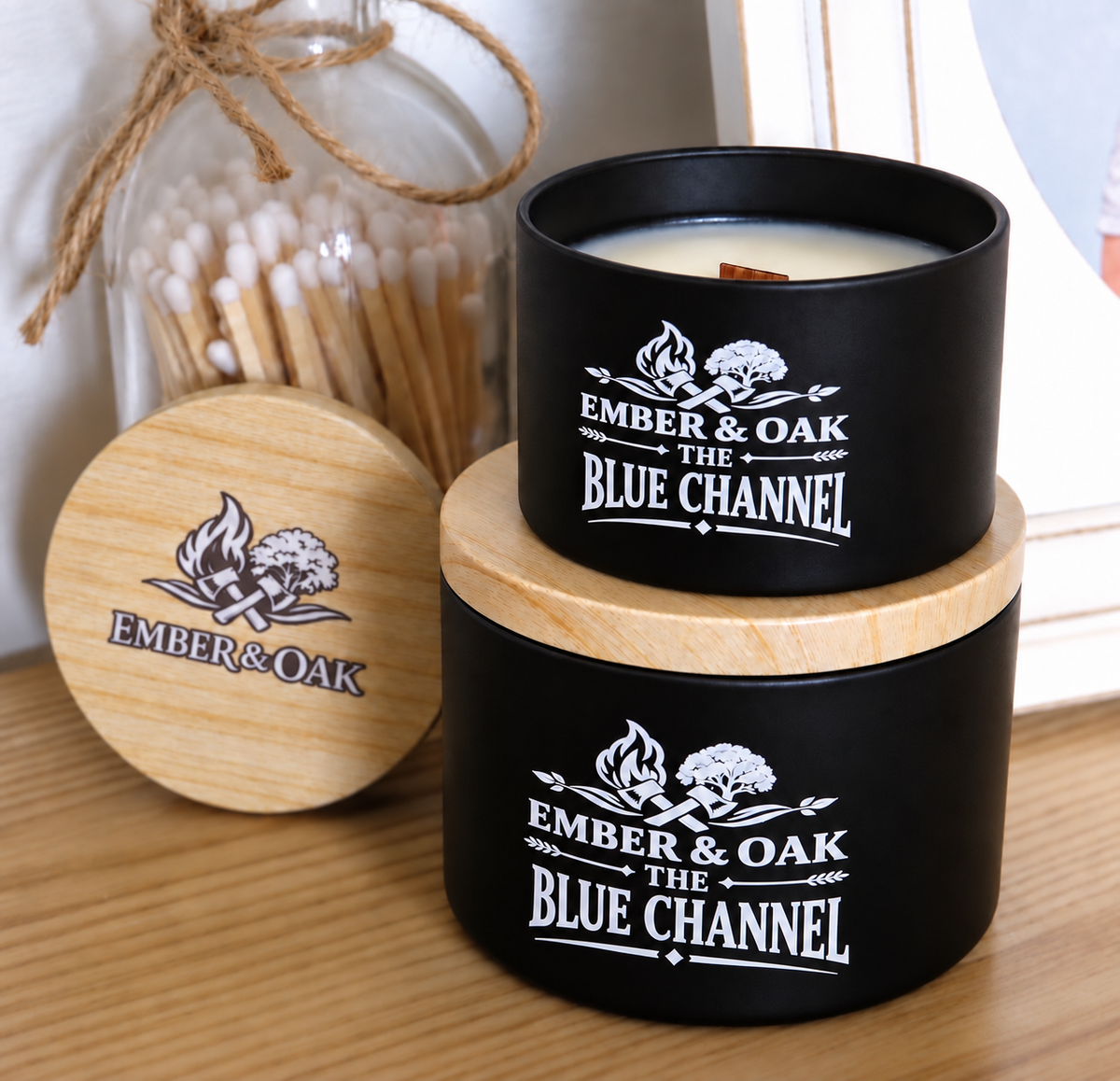     The Blue Channel luxury candle with wooden lid displayed alongside Ember & Oak packaging and accessories